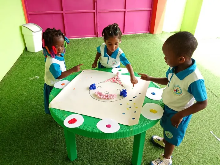 Enfants en uniforme autour d’une table d’atelier