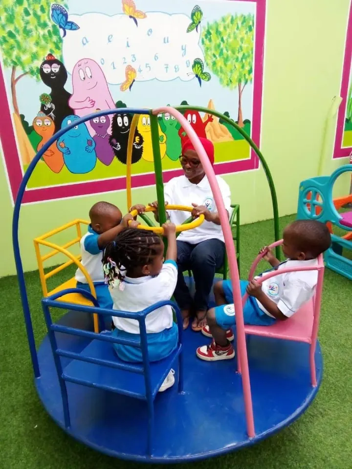 Enfants sur le manège de la cour
